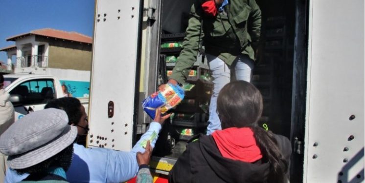 Residents queuing to buy bread from delivery trucks at exorbitant prices