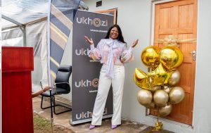 Shauwn Mkhize standing next to a recently built house