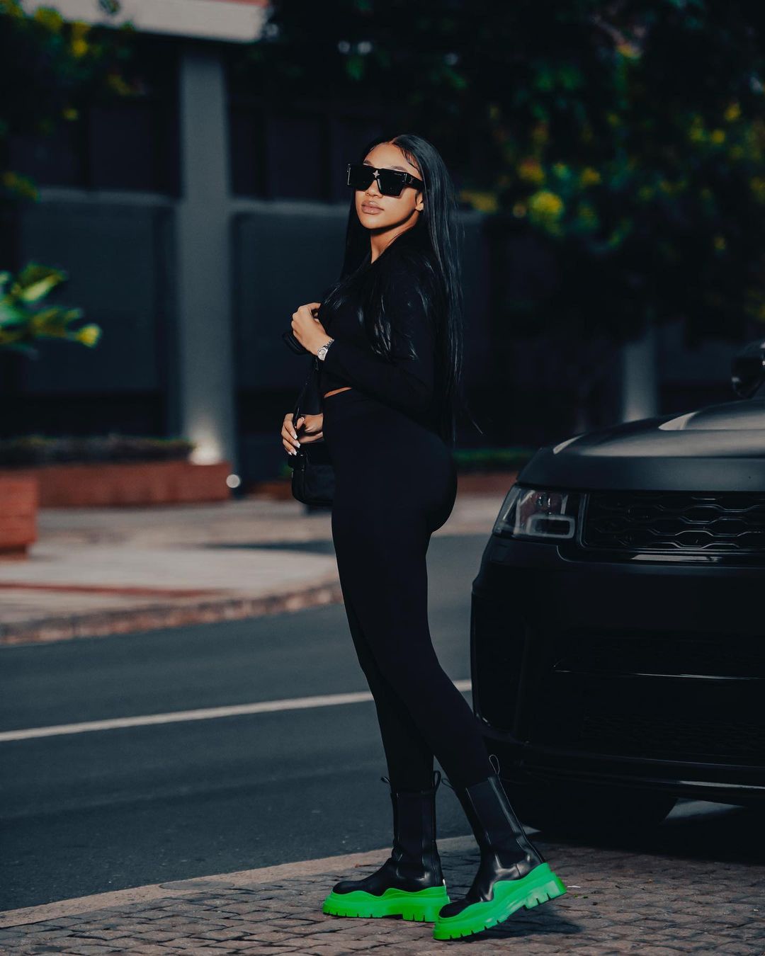 Tamia Mpisane standing to one of her luxury vehicles