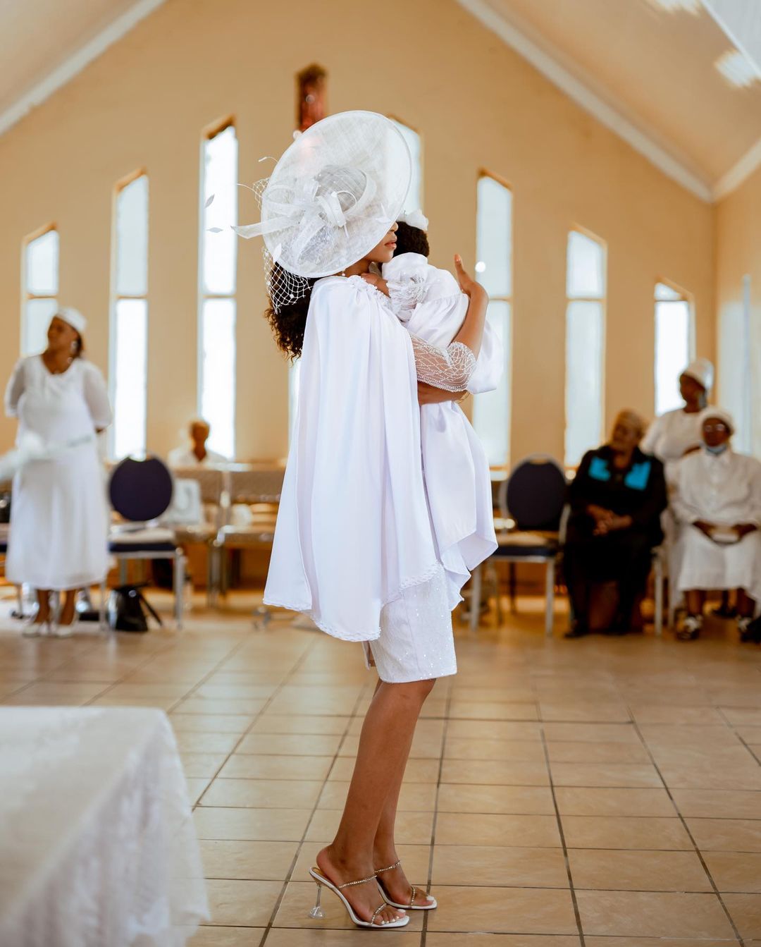 Blue Mbombo holding her baby in church