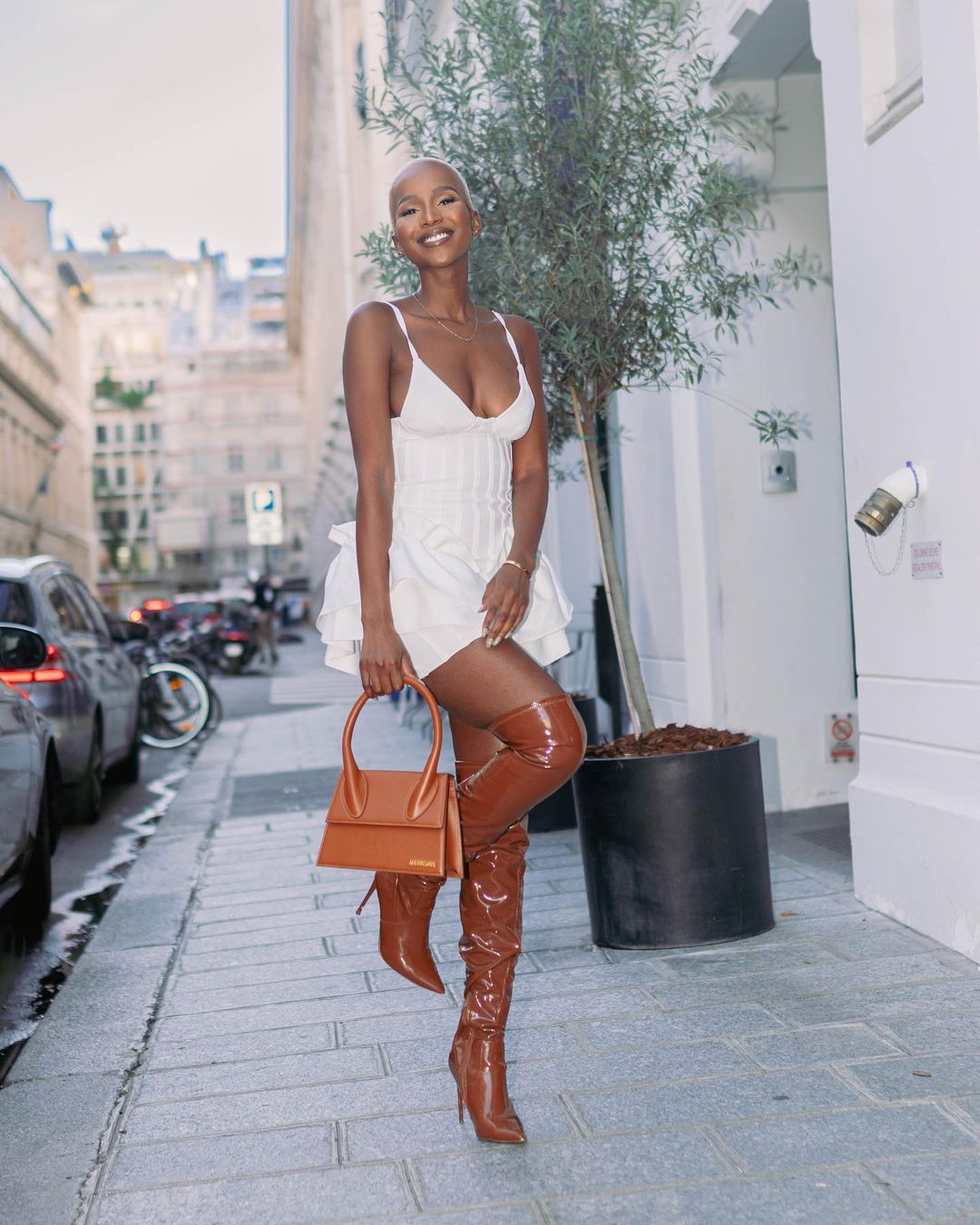 Shudufhadzo wearing a white dress and brown boots